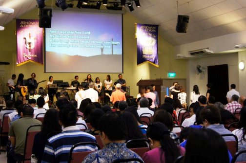 worship band leads congregation in song