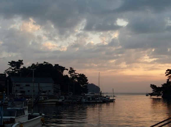 A lone fishing boat sets off into the sunrise