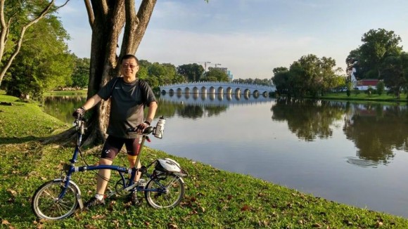 Pastor Richard Wong posing with his Brompton and with Chinese Garden in the background