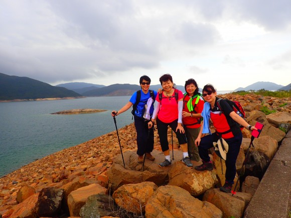 Colourful posing among red reservoir rocks by the shore