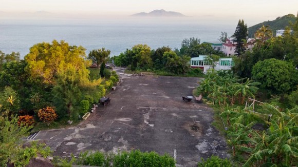 The large tennis court sized yard and sea view.