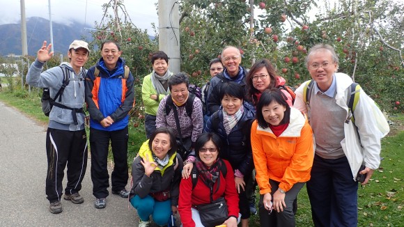 A group photo in front of the apple orchard.