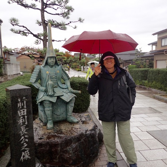 Tan standing beside the statue of