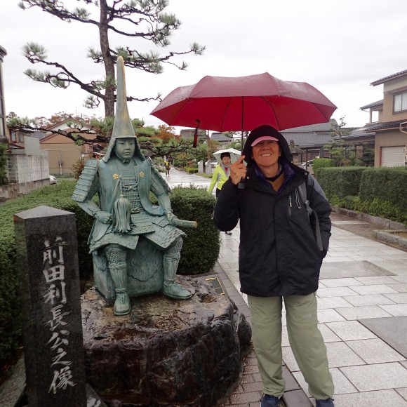 Tan standing beside the statue of 